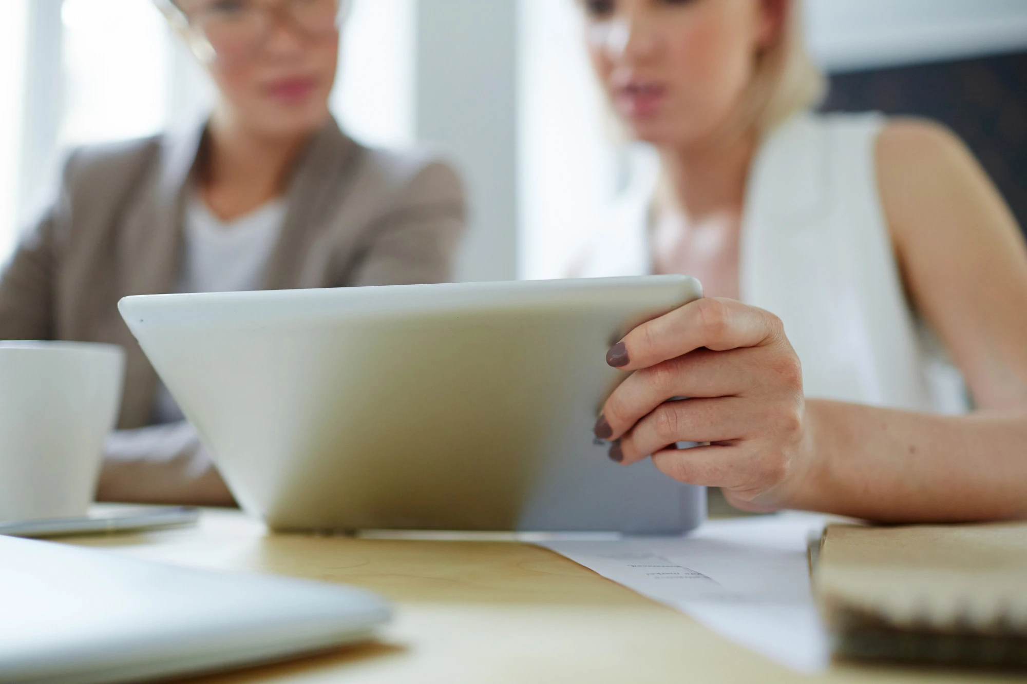 Mentora y directiva revisan información en una tablet durante una sesión de mentoría ejecutiva